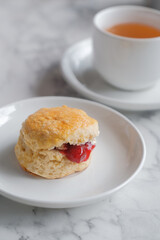 Tea with scones and clotted cream, jam, strawberries on the white table