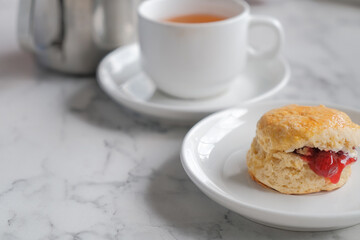 Tea with scones and clotted cream, jam, strawberries on the white table