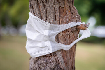 Face mask on a tree bark, sustainability, isolation and protection concept
