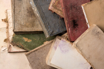 pile of old torn books, discolored and ruined pages, taken from above