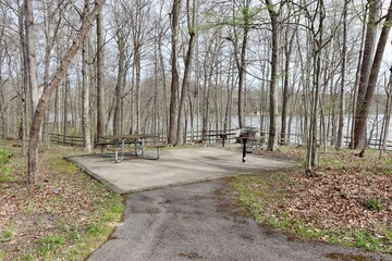 The picnic tables and grill in the park.