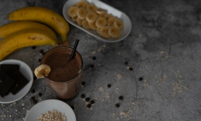 deliciosa bebida de chocolate, plátano y avena sobre fondo de piedra gris