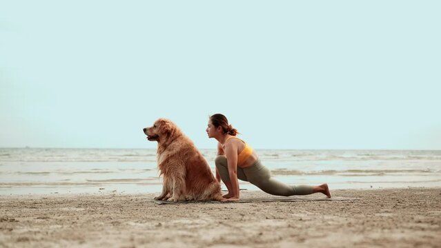 Asian Healthy woman doing yoga exercise with dog pet on the beach, Female relaxation healthy lifestyle on weekend concept, Enjoy life balance and freedom.