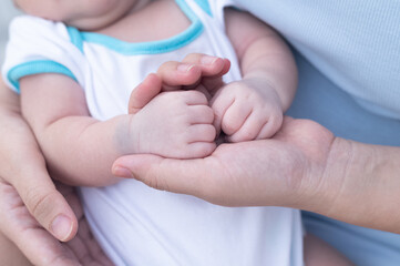 Closeup infant baby  Hand in hand mom, baby safe care skin