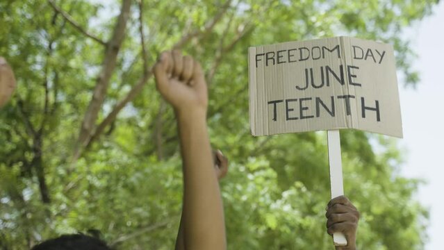 concept of Juneteenth freedom day march showing by close up protesting hands sign board - concept of activism, justice and demonstration