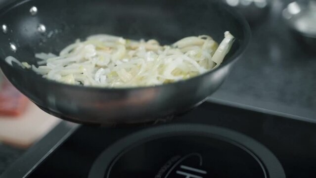 onions are fried in a frying pan in the kitchen