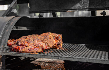 slow cooked beef brisket meat on the grill grates of a smoker barbecue