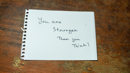 Hand written motivational word you are stronger than you think. lifestyle motivational positive words written on a wooden background. Business, signs, symbols, concepts. Copy space.