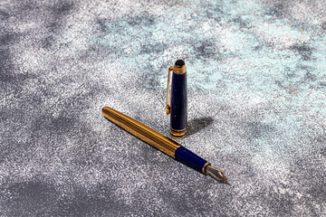 Fountain pen on a marble and gray background. Selective focus.