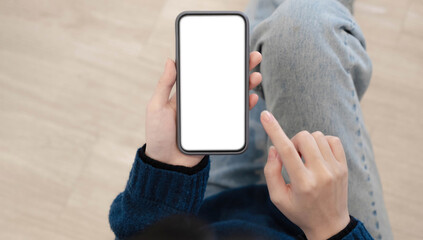 Top view of woman hands holding smart phone with blank copy space screen for your text message or information content.