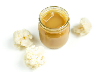 Baby food. A glass jar with children's mashed cauliflower puree on a white isolated background. The first lure of the baby.