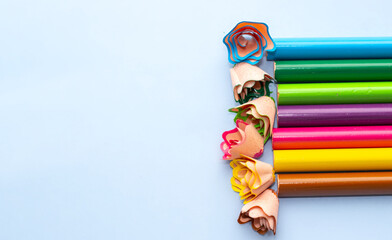 pencil shavings flower shape and colorful pencil in background.mock up space for text. art store, shop,back to school concept. horizontal or vertical photo.