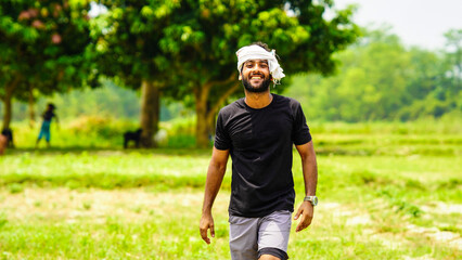 happy indian young farmer with his land in village