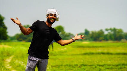 happy young farmer showing his land in village