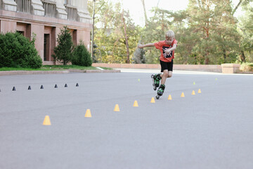 Happy inline skater slaloming between orange chips at skate park