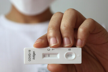 Man holding Rapid Antigen Test kit with Negative result during swab COVID-19 testing. Coronavirus Self nasal or Home test, ATK test for open the country concept.