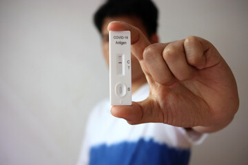 Man holding Rapid Antigen Test kit with Negative result during swab COVID-19 testing. Coronavirus...