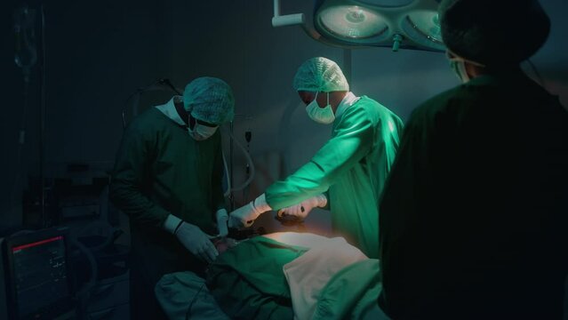 Professional doctors in the operating room making  CPR and use defibrillator electrical device to saving a patient life. health care concept.