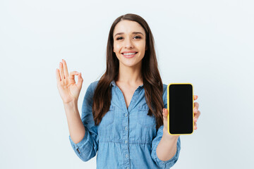 Fototapeta premium Happy confident young woman showing smartphone