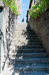 Long uphill stairway against walls for many concepts of going upwards, travel, fitness and more.