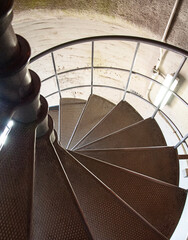 Looking down large circular stairs in rustic stairwell inside walls a pale yellow of these cool details.