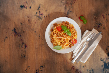 Pasta Spaghetti Bolognese in white plate on wooden background. Bolognese sauce is classic italian...