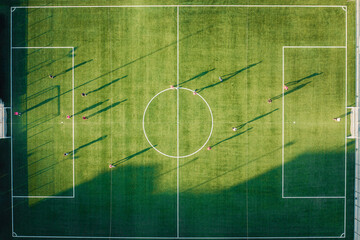 Football match on green field at sunset light - obrazy, fototapety, plakaty