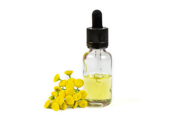 Essential oil of medicinal herb tansy in a bottle with a pipette on a white isolated background (isolate). Aromatherapy, spa, skin care.