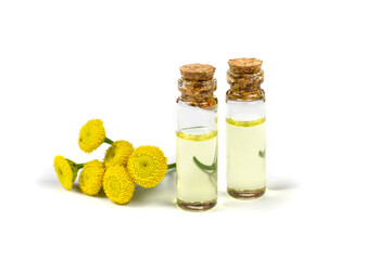 Essential oil of medicinal herb tansy in two glass bottles with a stopper on a white isolated background. Aromatherapy. Template, design.