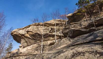 Autumn landscape with trees and rocks on top of a mountain against the sky
