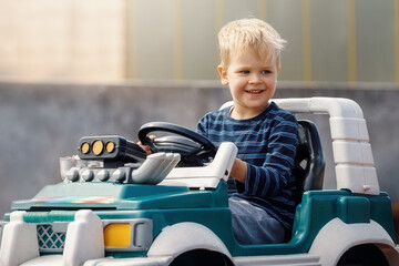 Young kid close up portrait with toy car outdoors.