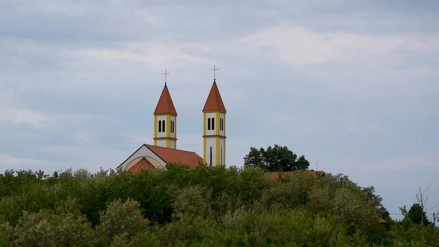 Roof and steeple of catholic church of Saint Anthony above forest on hill Topuz near Derventa