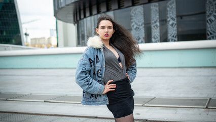 Fototapeta premium Beautiful girl posing against the backdrop of the urban landscape