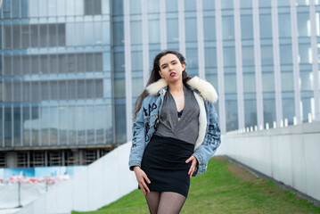 Fototapeta premium Beautiful girl posing against the backdrop of the urban landscape