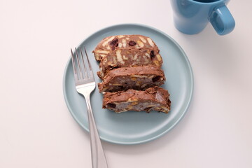 Homemade mosaic chocolate biscuit cake served in a blue plate, selective focus. It is called 