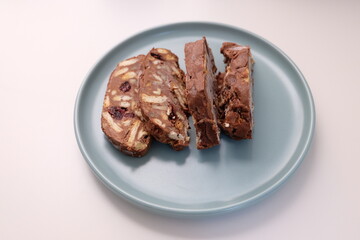 Homemade mosaic chocolate biscuit cake served in a blue plate, selective focus. It is called 