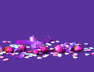 Festive concept from rosebuds and sweet hearts on purple background. Template mock up of greeting card or text design. Close-up