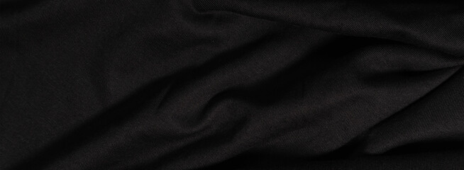 Black fabric background. Black wavy fabric in the dark
