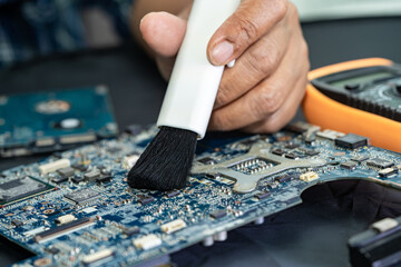 Technician use brush and air blower ball to clean dust in circuit board computer. Repair upgrade...