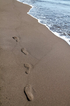 Traces on the black volcanic sand on the Khalaktyrsky beach of the Pacific Ocean. High quality photo