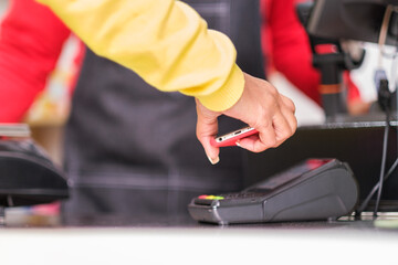 Unrecognizable hands paying through smartphone