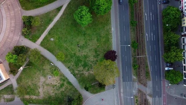 From park to busy big street along houses.
Fantastic aerial view flight drone shot footage from above
of Berlin Prenzlauer Berg Allee Summer 2022. Cinematic travel guide by Philipp Marnitz