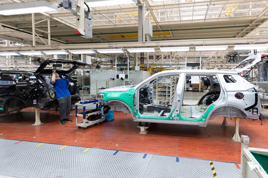 Car bodies are on assembly line. Factory for production of cars. Modern automotive industry. A car being checked before being painted in a high-tech enterprise