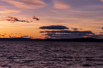 Beautiful orange and red clouds during sunset at the sea in Norway