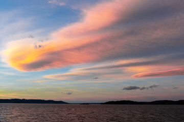 Beautiful orange and red clouds during sunset at the sea in Norway