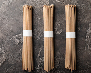 Buckwheat paste on a black cement background. Raw noodles. Ingredients for a gluten-free dish. Dried buckwheat soba noodles. Traditional Japanese food. Healthy food. Place to copy.