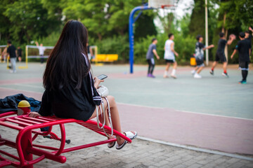 The back of a woman sitting watching the game