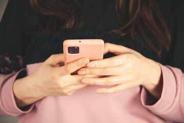 woman hand holding smart phone on gray background