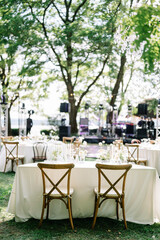 magical rustic wedding tables outside in the garden with hanging light and flowers, chairs, outdoor...