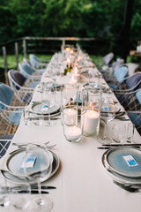 Wedding table serving. Wedding banquet. Beautiful festive table decorated with bouquet of flowers, black plate with card of name guest and cutlery. Top view